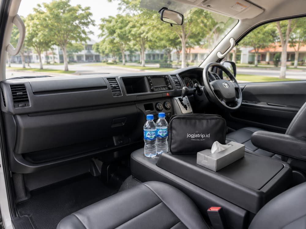 Dashboard bersih, air mineral, dan travel kit jogjatrip.id di Hiace Premio